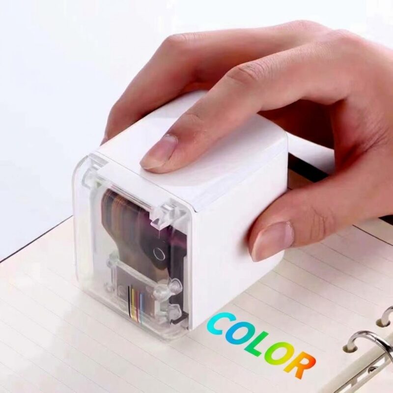 Hand holding the printer and marking the word COLOR onto a sheet of paper